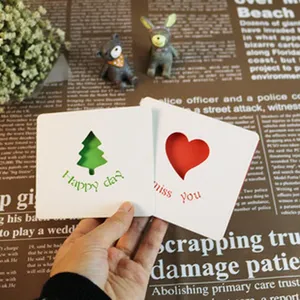 Gros plan de cartes de vœux blanches créatives avec des découpes d'arbres et de cœurs.