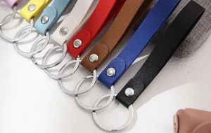 Gedetailleerd overzicht van kleurrijke lederen sleutelhangerriempjes met metalen drukknoppen.