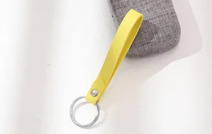 Gele lederen sleutelhanger detailopname, eenvoudig bandontwerp met metalen ring voor tassen.