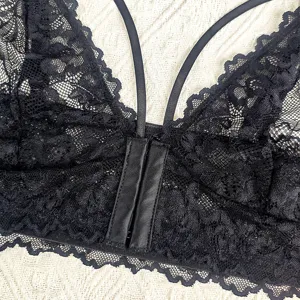 Gros plan détail du haut bralette noir en dentelle avec fines bretelles et texture élégante.