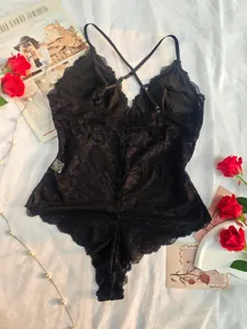 Black lace sexy cross strap open back teddy lingerie, elegant flat lay detail shot.