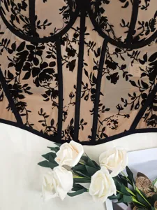 Close-up detail of sexy lace corset top featuring black floral mesh and structured boning design.
