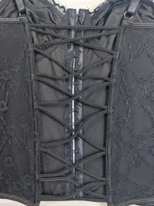Black lace corset top detail featuring patterns, criss-cross lacing and hook closures.