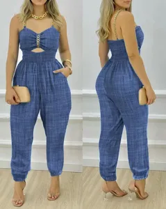 Vista dettagliata della tuta da donna blu stile denim con spalline a catena e vita smocked.