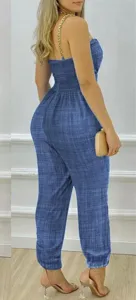 Vista dettagliata di tuta da donna blu stile denim con eleganti spalline a catena.