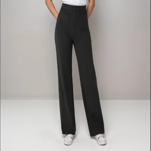 Detail view of women's high-waisted straight trousers with multiple pockets and buttons.