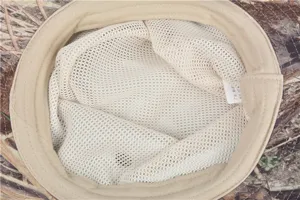 Detailed view of the breathable white mesh lining and neat stitching inside the camo hat.