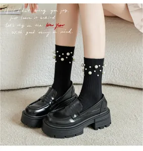 Gros plan de chaussettes noires côtelées avec des perles associées à des mocassins épais.