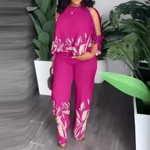 Completo due pezzi fucsia da donna con top di perle e pantaloni lunghi stampati.