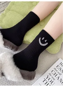 Black ribbed mid-calf socks featuring a sparkly rhinestone winking smiley design.