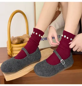 Detail view of maroon ribbed socks featuring elegant pearl and rhinestone details.