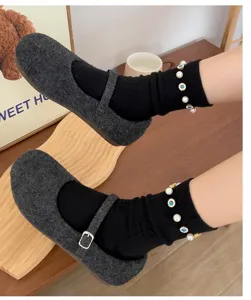 Detailed shot of trendy women pearl crystal mid-calf socks paired with cute shoes.