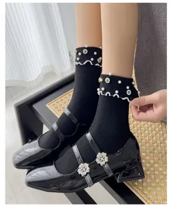 Black mid-calf socks with pearls rhinestones and ruffles paired with Mary Jane shoes