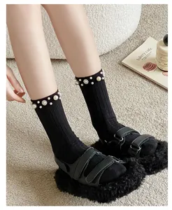 Black pearl embellished ribbed mid-calf socks detail shot showing elegant cuffs and soft knit texture.