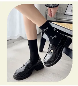 Detailed shot of sweet black mid-tube socks featuring white pearl and bow accents with shoes.
