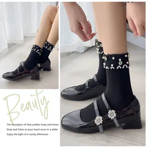 Detailed view of stylish black mid-tube socks with elegant pearls, rhinestones and ruffles.