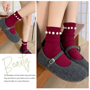 Gros plan détaillé de chaussettes en maille rouge perlé avec strass et chaussures rétro.