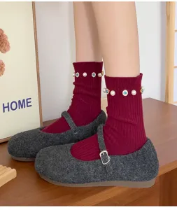 Close-up detail of women's autumn winter red ribbed socks with pearls and fuzzy Mary Jane shoes.