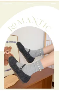 Vue detaillee de chaussettes grises pour femmes avec perles et strass et chaussures laine.
