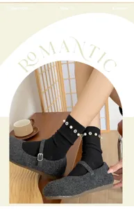 Detail of black mid-calf socks with pearls and rhinestones, styled with grey mary jane shoes.