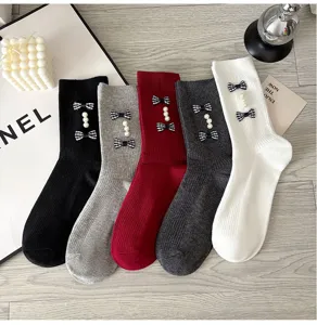 Detailed shot of women mid-calf socks with plaid bows and pearls, cute style multi-color.