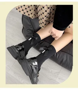 Close-up detail of black mid-calf socks featuring cute ribbon bows and pearl accents for daily wear.
