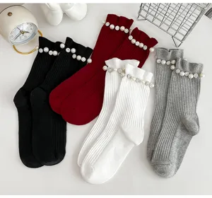 Vue détaillée de chaussettes mi-mollet côtelées ornées de perles et de strass élégants.