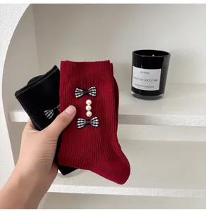 Detailed view of women knit socks featuring plaid bows and pearl decor for sweet autumn wear.