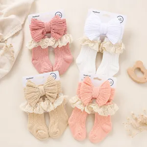 Set fascia e calzini in maglia per neonati con grande fiocco e dettagli in pizzo per bambina.