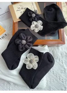 Black mid-calf socks featuring elegant 3d fabric flowers and sparkly rhinestone centers.