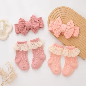 Primo piano dettagliato di simpatiche fasce per capelli in maglia da neonato e calzini con volant rosa.