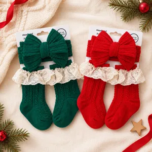 Dettaglio del set di fascia in maglia e calzini per neonato di Natale in rosso e verde.