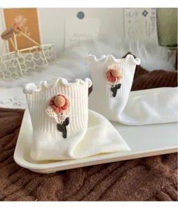 Sweet white mid-calf socks featuring delicate ruffled edges and charming daisy floral decor.