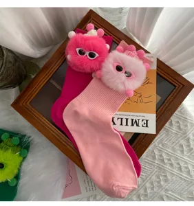 Detail view of cute fluffy monster doll mid-calf socks with playful glasses in pink.