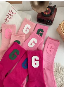 Détail chaussettes mi-mollet roses avec patch lettre G en cuir PU, style collégien coton confortable.