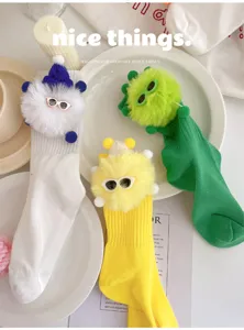 Detail view of cute fluffy monster elf kids socks with funny sunglasses, soft cotton fabric.