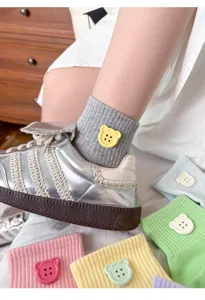 Close-up detail of cute dopamine ribbed short socks featuring adorable bear buttons.