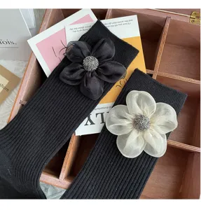 Women black mid-tube socks featuring 3D fabric flower and rhinestone center, stylish cozy winter knit socks.