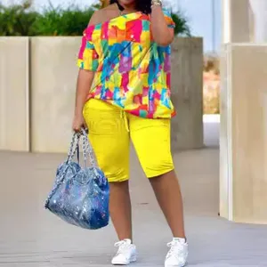 Ensemble d'été pour femme t-shirt court imprimé coloré épaules dénudées et short plissé jaune.