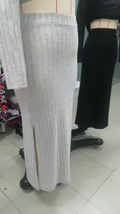 Detailansicht des hochgeschnittenen Rippenstrickrocks mit Seitenschlitz in neutralen Tönen.