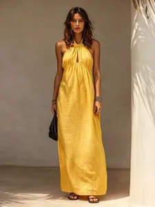 Detailaufnahme des eleganten gelben Halfter-Maxikleides, getragen vom Model draußen.