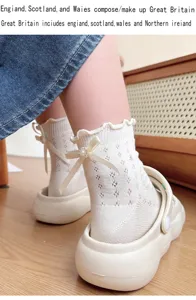 Detail view of white lace ruffle mid-tube socks with elegant bow and pearl for women.