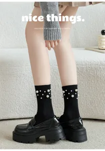 Chaussettes mi-hautes noires avec perles, associees a des mocassins de style japonais chic.