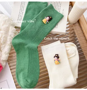 Detailed view of sweet Japanese style vertical stripe mid tube socks with Tang doll charms.