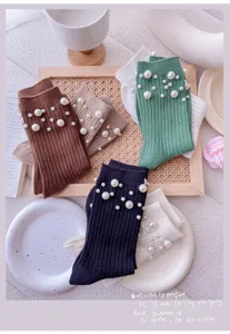 Detail view of women's knit crew socks decorated with elegant faux pearls, stylish and cozy.