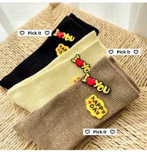 Detailed view of fashionable mid-tube stacking socks featuring cute 3D silicone letter patches.