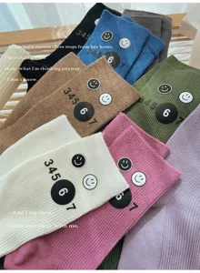 Colorful stackable mid-calf socks for women, featuring cute numbers and smiley print.