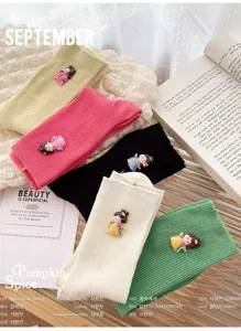 Detail view of cute knit crew socks with Chinese Tang style doll decor, soft textured fabric.