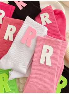 Close-up detail of soft label letter R mid-calf socks in various sweet colors for women.