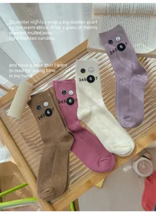 Close-up detail shot of colorful ribbed stacking socks with smiley and number prints.
